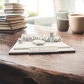 Handmade model of the Ravenswood wedding venue on a rustic wooden table with books and mugs