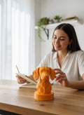 a low poly orange sausage dog bust on a plinth on office desk
